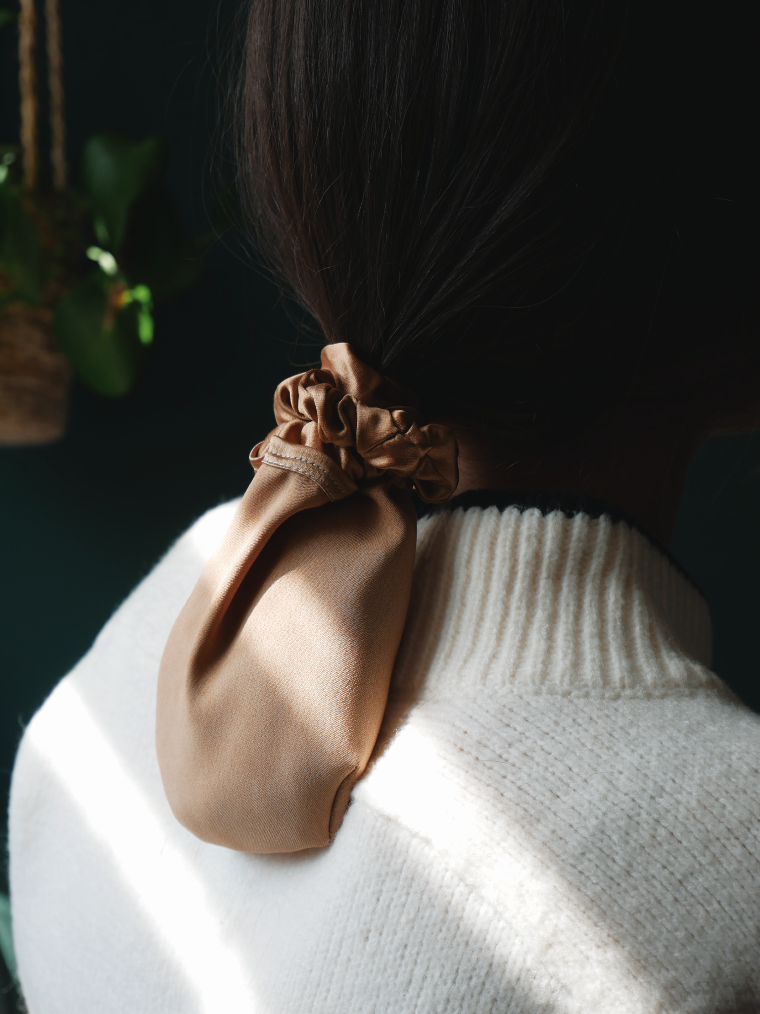 Frau trägt Silk Bun in den Haaren, dunkelgrüner Hintergrund