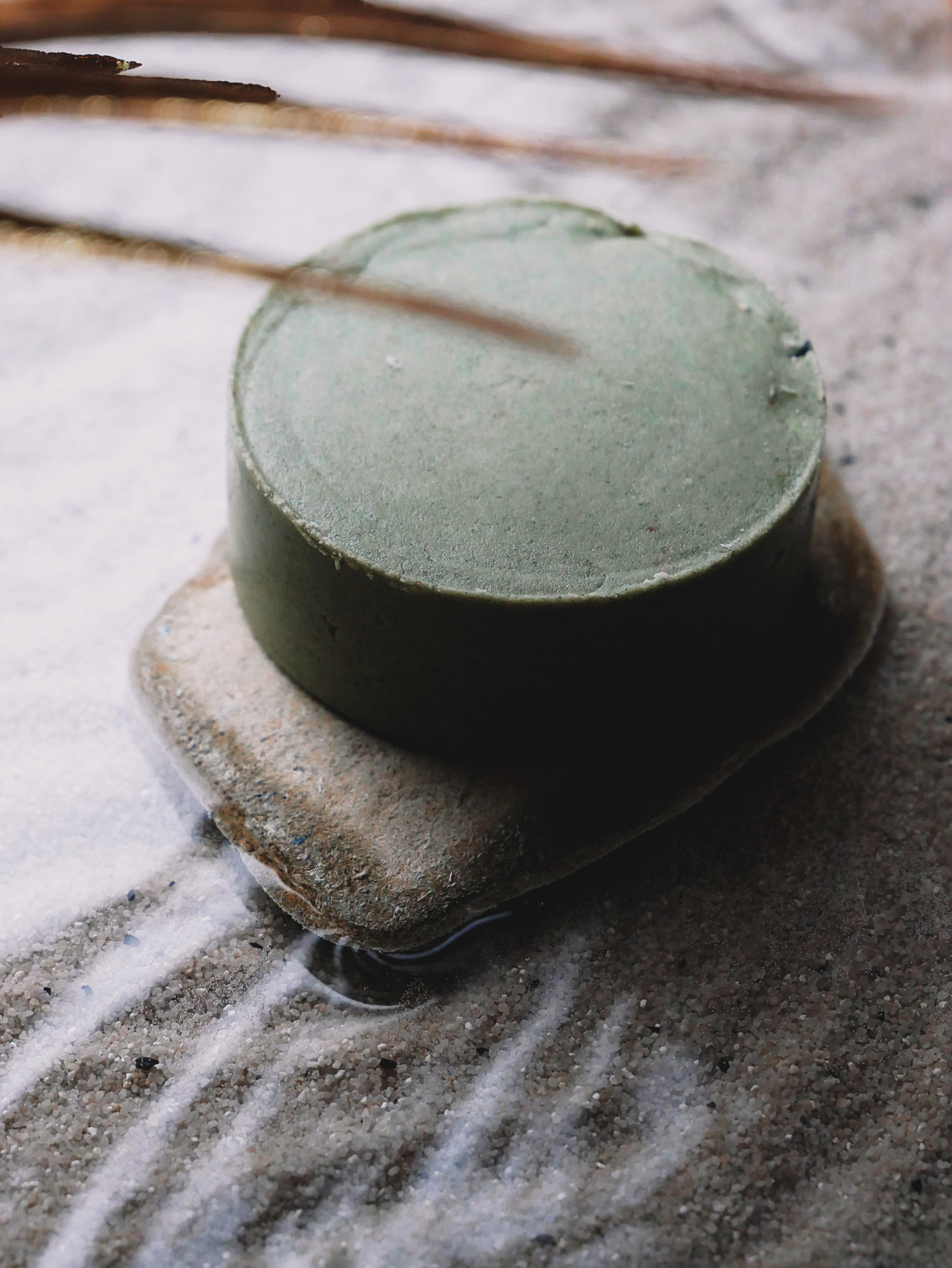 festes-shampoo-milde-hilde-liegend-auf-stein-und-sand